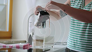 Woman makes coffee latte in geyser coffee maker at home