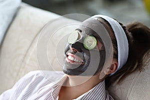 Woman makes gray clay facial mask at home