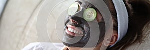 Woman makes gray clay facial mask at home