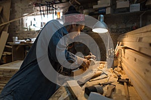 Woman makes a work of wood in the workshop.