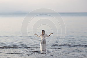 Woman makes yoga exercises in front of ocean