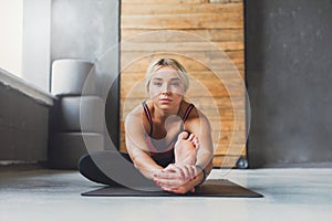 Woman makes yoga pose in class, sit forward bend asana