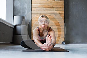 Woman makes yoga pose in class, sit forward bend asana