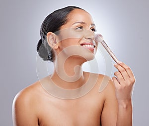 Woman, makeup and brush for beauty application in studio on white background, wellness or cosmetics. Female person