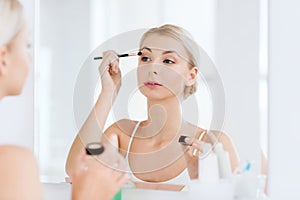 Woman with makeup brush and eyeshade at bathroom