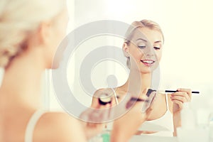 Woman with makeup brush and eyeshade at bathroom