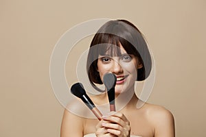woman makeup brushes in hand model makeup posing  background