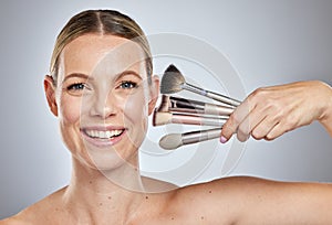 Woman, makeup brushes and portrait smile for cosmetics, beauty or facial treatment against a studio background. Happy