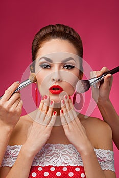 Woman with makeup brushes. She is standing