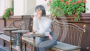 Woman makeup face dreamy brunette eat cake cafe terrace background. Gastronomical enjoyment. Gourmet concept. Girl relax