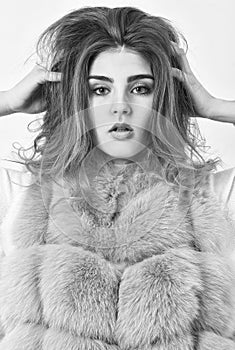 Woman makeup face touch hair volume hairstyle. Girl fur coat posing with hairstyle on white background. Winter hair care