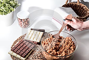 A Woman Making 3 Chocolates cake Pie, Ingredients on the table. Kitchen with white, dark and milk chocolate