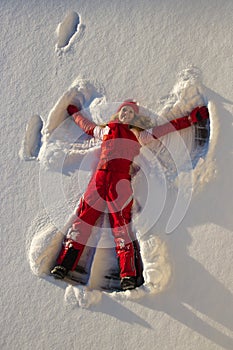 Woman making an angel on snow
