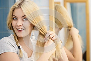 Woman making braid on blonde hair