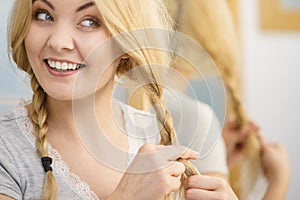 Woman making braid on blonde hair