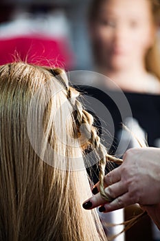 Woman making braids at hair studio