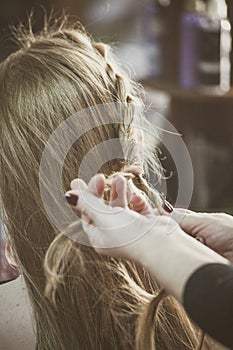 Woman making braids at hair studio