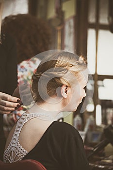 Woman making braids at hair studio