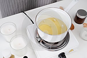 woman making candles melting soy wax in the jar