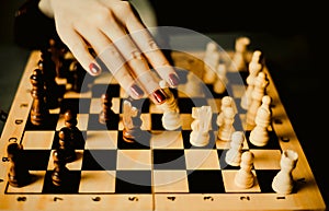 A woman making a chess move to checkmate her opponent. The strategy, intellectual challenges, and competition