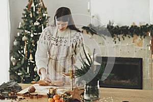 Woman making christmas gingerbread cookies. Hands kneading gingerbread dough with rolling pin, golden cutters, cooking spices,