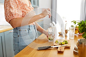 woman making cocktail drinks at home kitchen