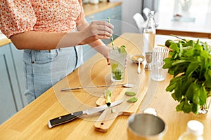 woman making cocktail drinks at home kitchen