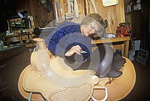 Woman making custom made western saddle