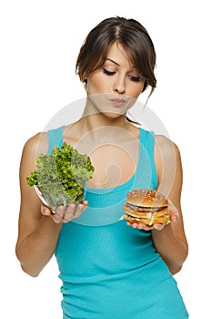 Woman making decision between healthy salad and fast food