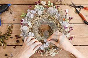 Woman making door wreath with autumn plants and flowers