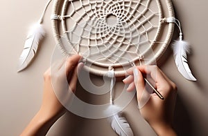 Woman making dream catcher on light table, closeup view