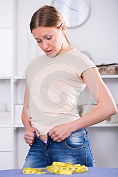 Woman making efforts to button up jeans