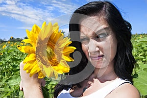 Woman making face at sunflower