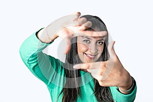 Woman making frame with her fingers over white background