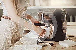 Woman making fresh espresso in coffee maker. coffee machine make