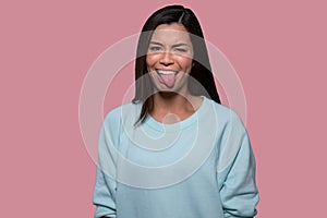 Woman making funny goofy face with tongue sticking out, expressive comedic asian american portrait