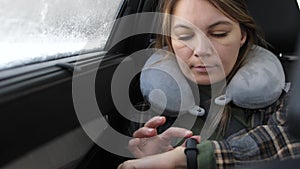 Woman making gestures on a wearable smartwatch computer device while traveling in car. smart watch. close up. 4k