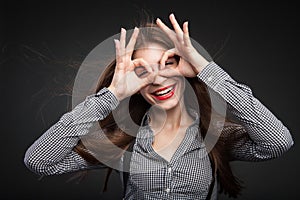 Woman making glasses out of her hands.