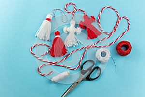 Woman making handmade traditional martisor, from red and white strings with tassel. Symbol of holiday 1 March, Martenitsa, Baba photo