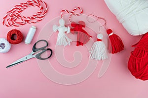 Woman making handmade traditional martisor, from red and white strings with tassel. Symbol of holiday 1 March, Martenitsa, Baba photo