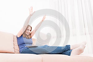 Woman making happy gesture with hands holding laptop