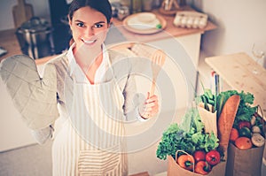 Woman making healthy food standing smiling in kitchen