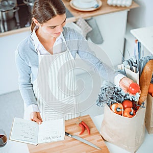 Woman making healthy food standing smiling in kitchen