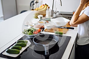 Woman making healthy salad from fresh vegetables