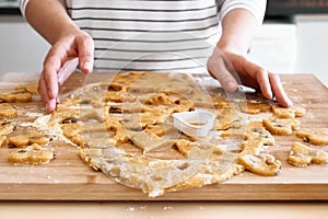 Woman making heart shaped cookies on the table in the kitchen. Gluten free flour cookies. Homemade healthy eating.