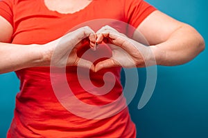 Woman making heart shaped hands, heart health insurance, social responsibility, gratitude, donation, happy charity