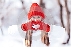 Woman making heart symbol with snowy hands