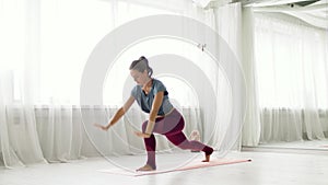 Woman making high lunge exercise at yoga studio