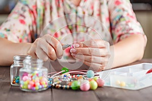 Woman making home craft art bijouterie