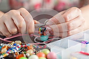 Woman making home craft art bijouterie